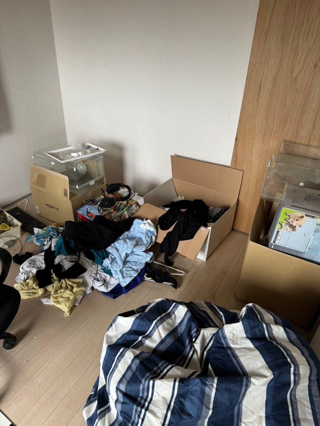 男性の少し散らかった部屋の片付け時に衣類、段ボール回収